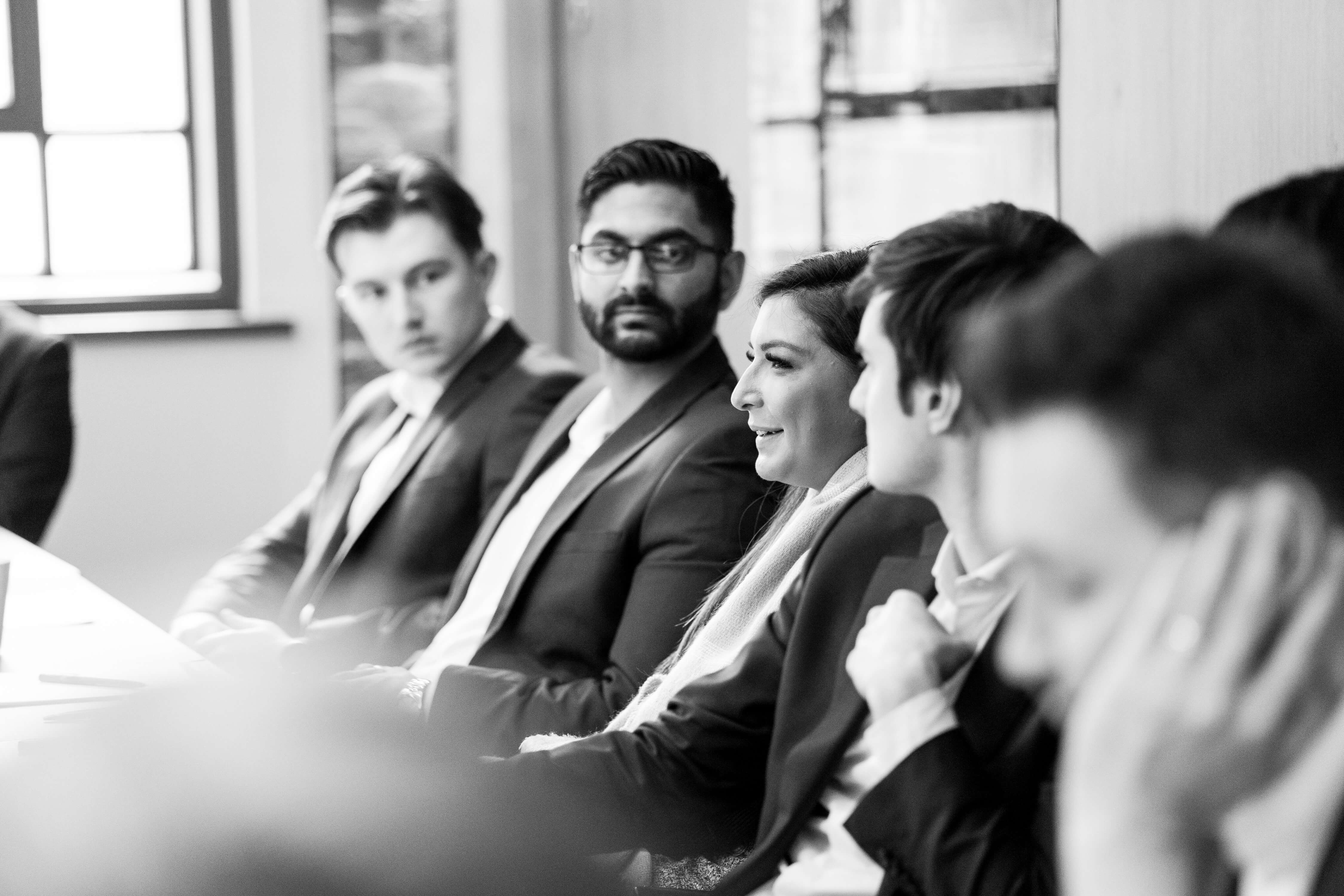 A black and white image of VantagePoint consultants having a meeting.